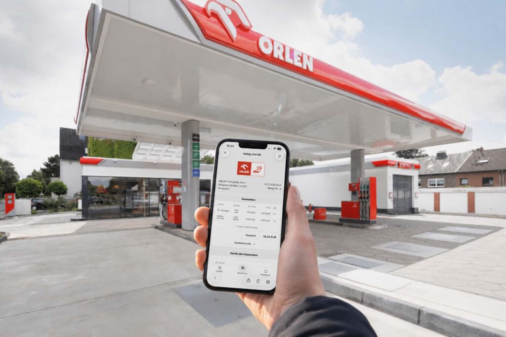 Hand holding a smartphone displaying an Orlen and Star digital receipt at beleg.star.de, with an Orlen fuel station forecourt in the background.